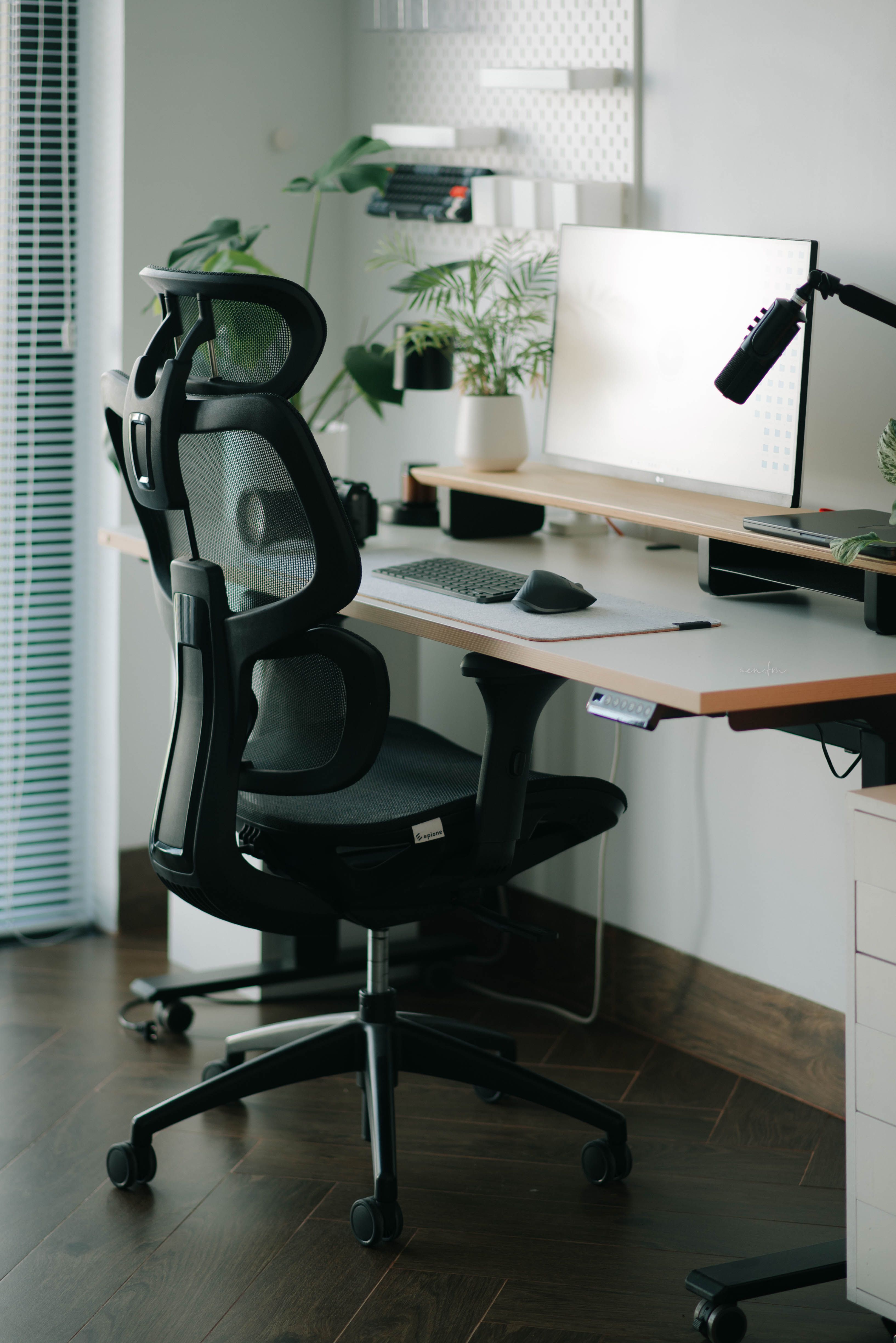 Ergonomischer Bürostuhl mit Armlehnen an einem höhenverstellbaren Schreibtisch mit Monitor